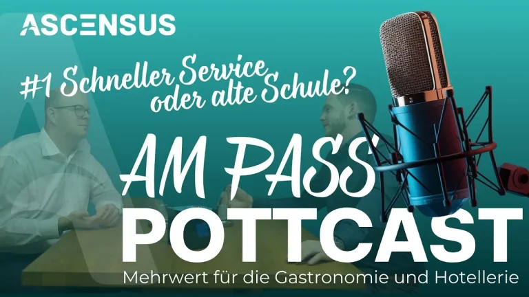 Philipp und Robert sitzen am Tisch und schauen in die Kamera bei der Podcastaufnahme