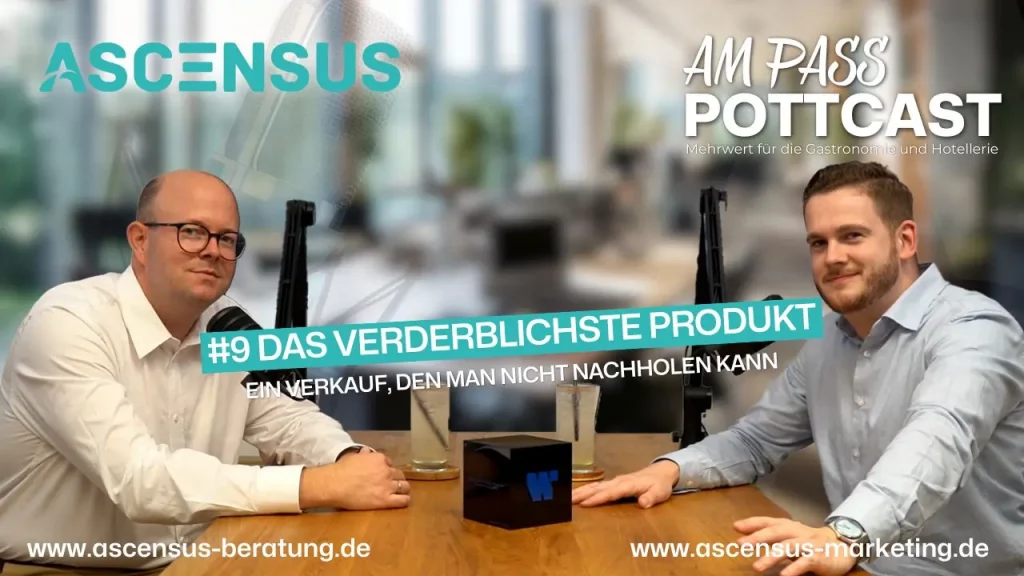 Philipp und Robert sitzen am Tisch und schauen in die Kamera bei der Podcastaufnahme